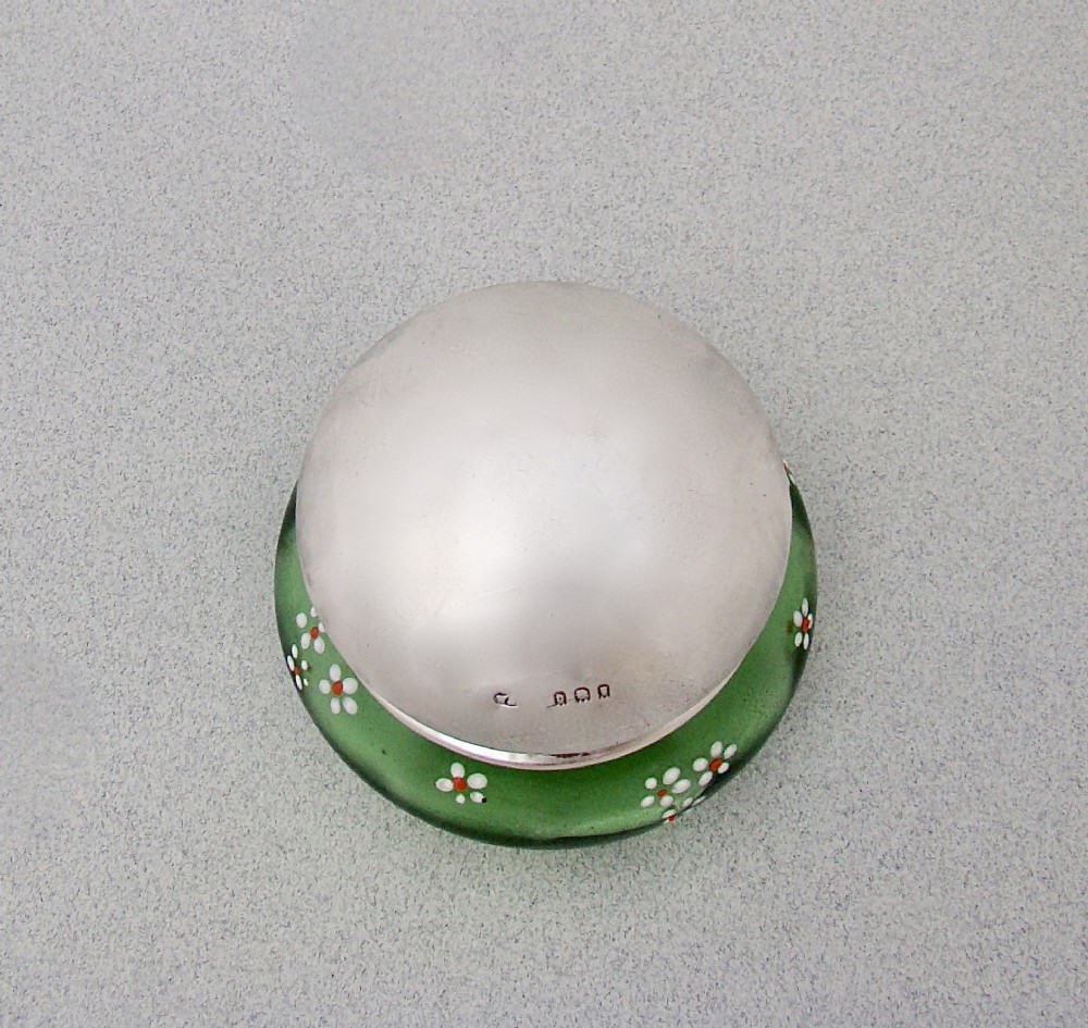 A small green glass jar decorated with white enamel flowers and topped with a hallmarked sterling silver cap. View III