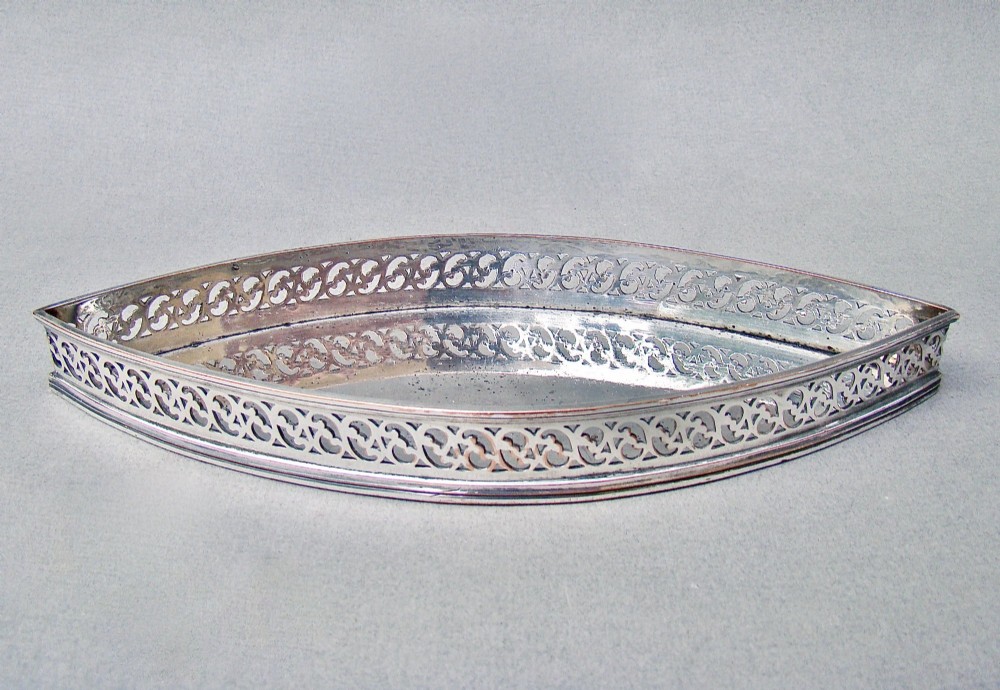 A boat-shaped Georgian Old Sheffield plate snuffer tray featuring a pierced lattice gallery rim.