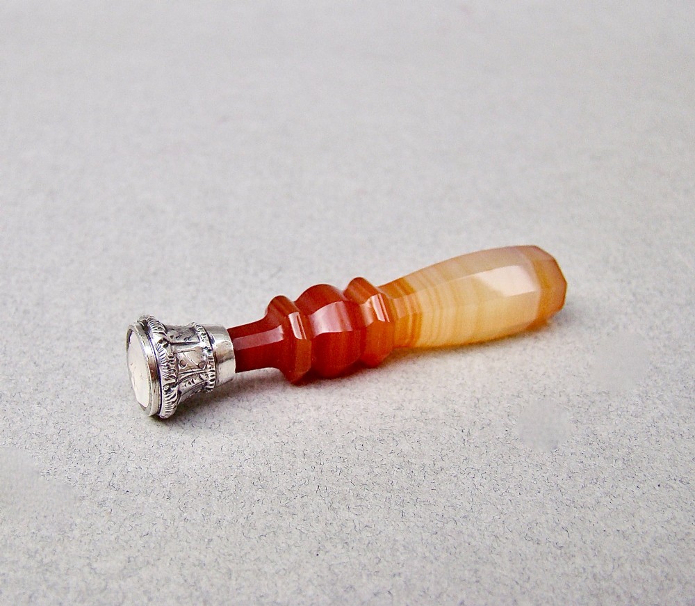 A Victorian desk seal featuring a carved red and cream banded agate handle with an engraved silver mount. View III