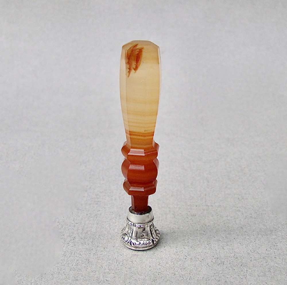 A Victorian desk seal featuring a carved red and cream banded agate handle with an engraved silver mount. View IV