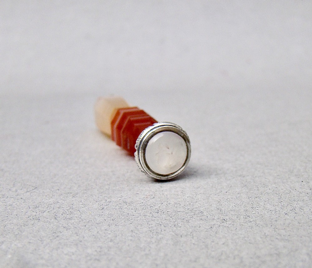 A Victorian desk seal featuring a carved red and cream banded agate handle with an engraved silver mount. View V