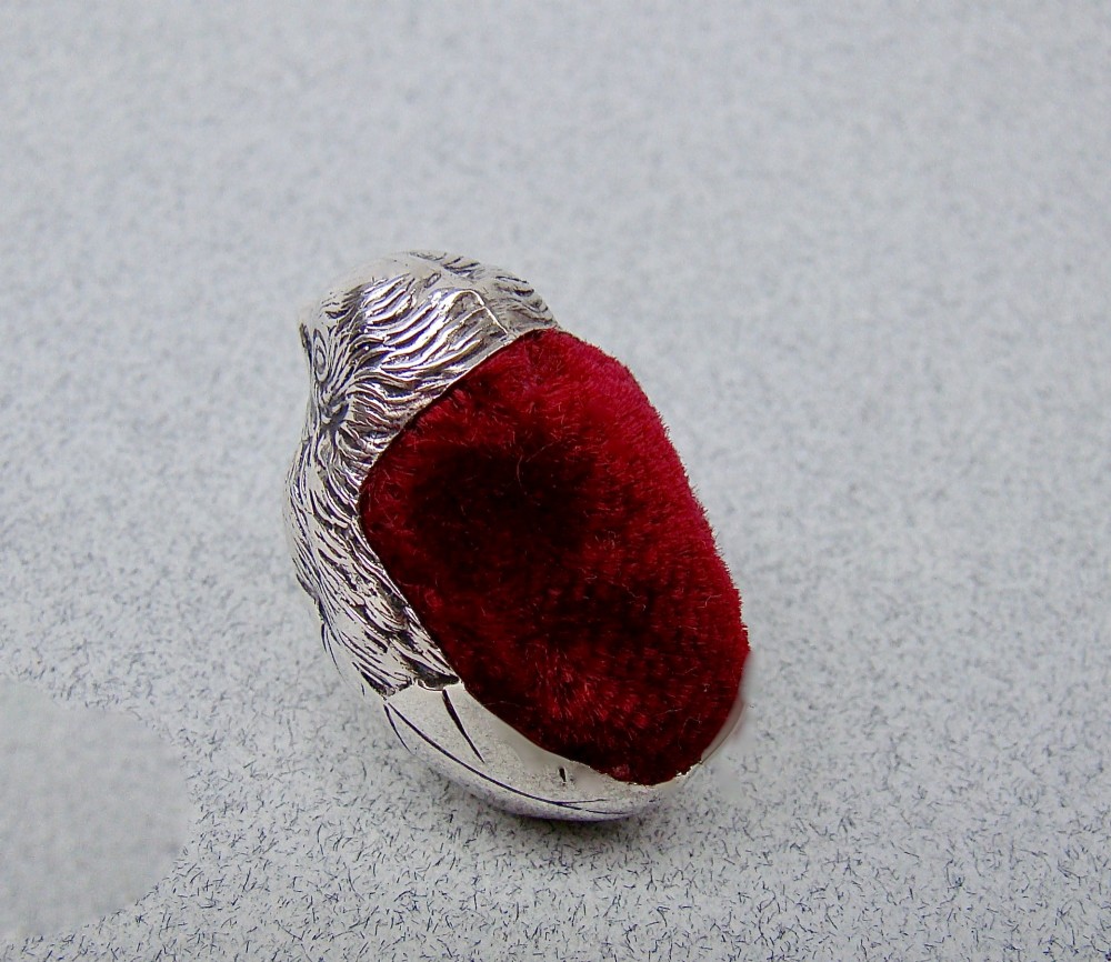 An Edwardian sterling silver pin cushion formed as a hatching chick emerging from an eggshell with a red velvet insert. View V