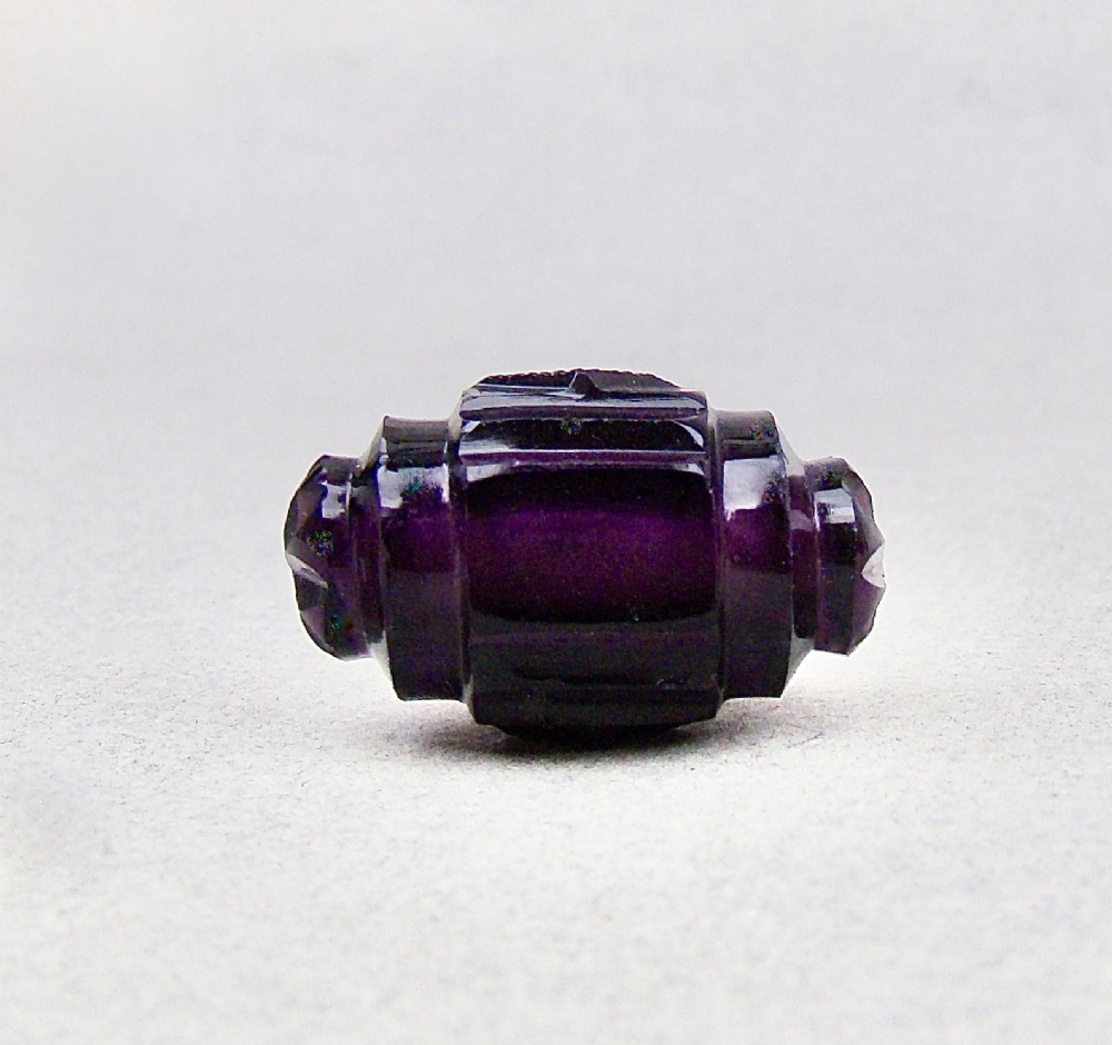 A miniature barrel-shaped purple amethyst cut glass scent bottle with a silver cap and collar. View VII
