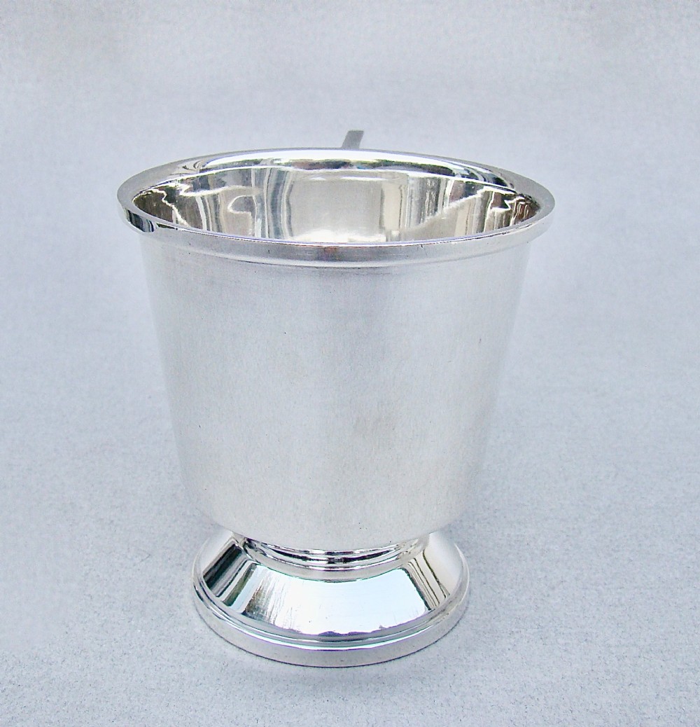 A sterling silver Art Deco christening mug with a flared body, geometric angular handle, and stepped pedestal base. View VI