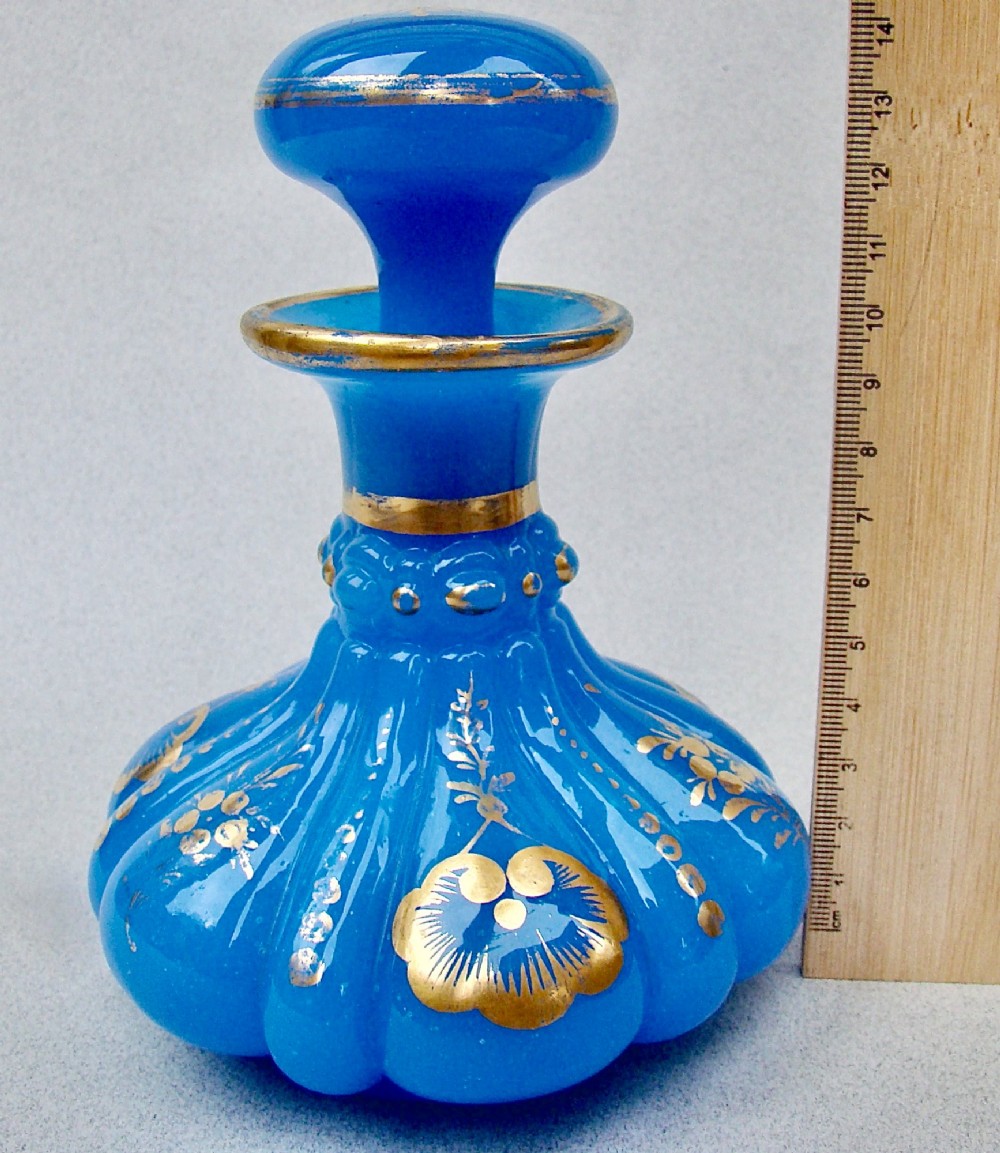 A bright blue lobed opaline glass scent bottle with a flared rim, ground glass stopper, and hand-gilded floral motifs. View III