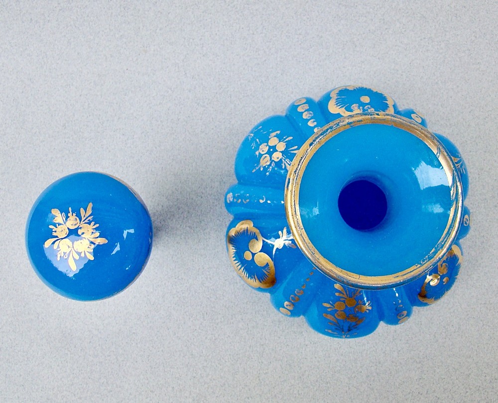 A bright blue lobed opaline glass scent bottle with a flared rim, ground glass stopper, and hand-gilded floral motifs. View IV