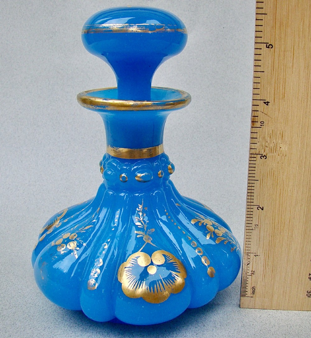 A bright blue lobed opaline glass scent bottle with a flared rim, ground glass stopper, and hand-gilded floral motifs. View VI