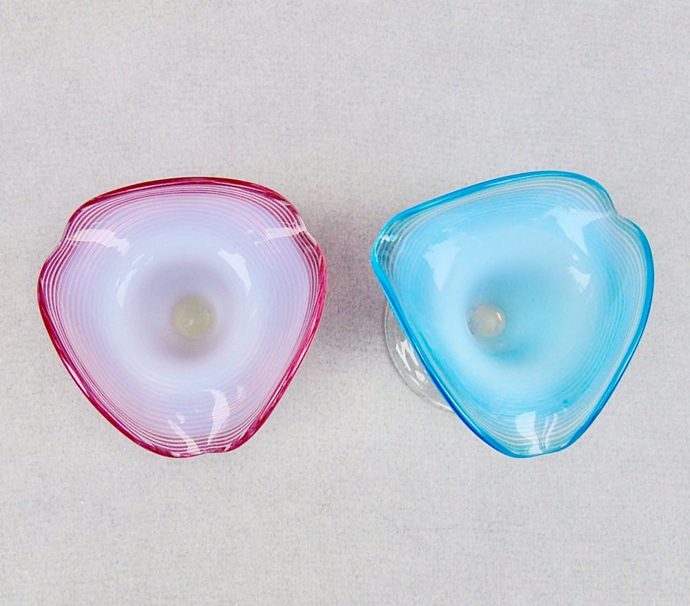A pair of late Victorian opaline glass candlesticks with coiled threaded bodies and wide frilled rims, one in pink and one in turquoise blue. View IV