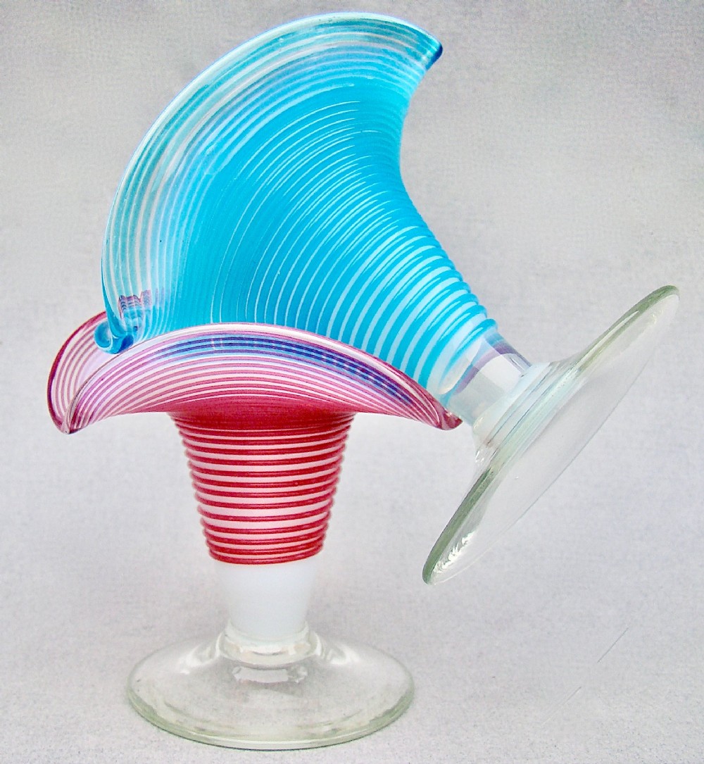 A pair of late Victorian opaline glass candlesticks with coiled threaded bodies and wide frilled rims, one in pink and one in turquoise blue. View V