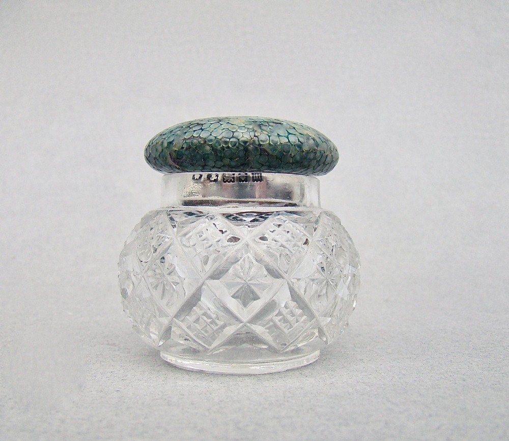 An Art Deco cut glass rouge pot with a hallmarked silver collar and a domed green shagreen lid.