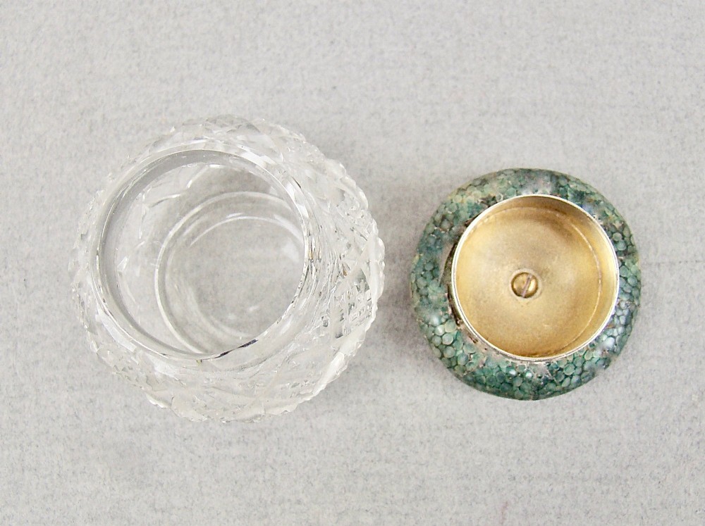 An Art Deco cut glass rouge pot with a hallmarked silver collar and a domed green shagreen lid. View V