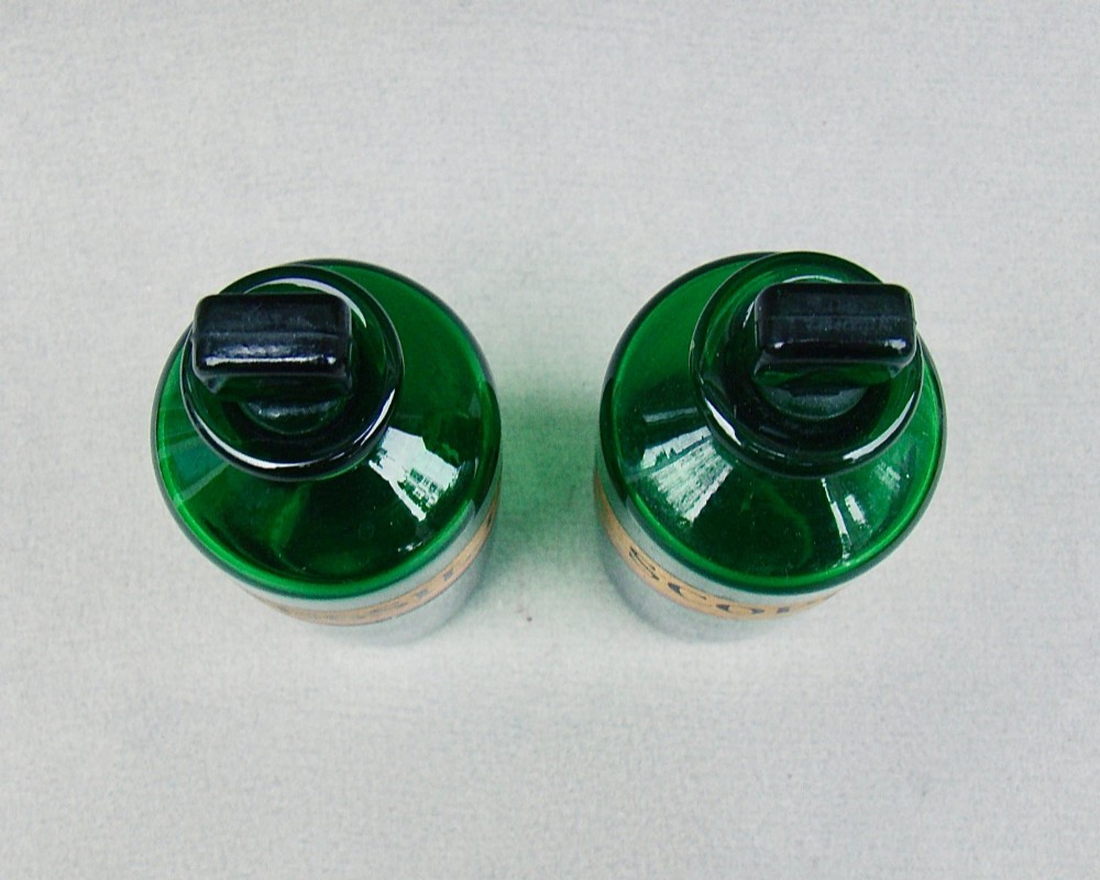 A pair of late Victorian cylindrical Bristol green glass apothecary bottles with ground stoppers and gilt-painted labels. View IX