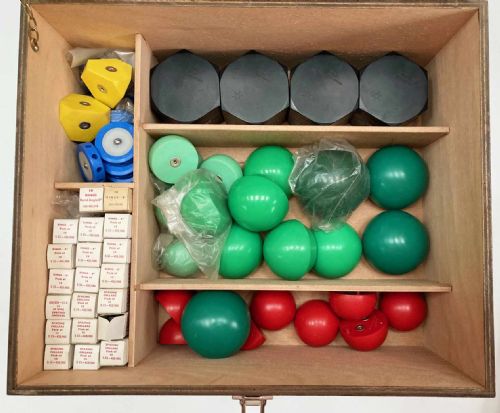 fig 5. A vintage wooden case filled with colourful plastic atomic model components, accompanied by an instructional booklet and a printed chart inside the lid.