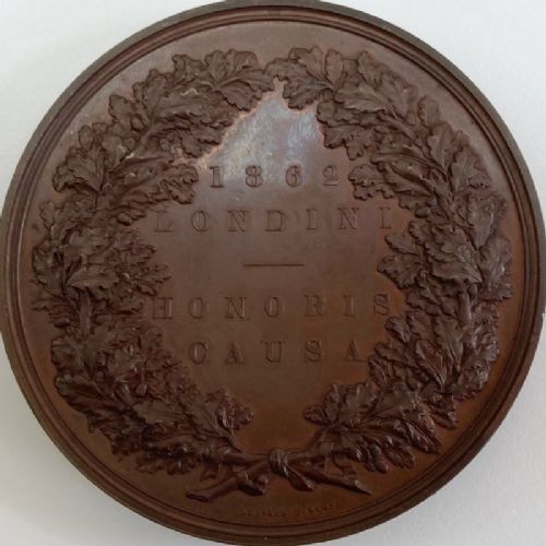 fig 1. A circular dark brown bronze medallion featuring high-relief classical allegorical figures surrounding a seated Britannia with a recumbent lion at her feet.