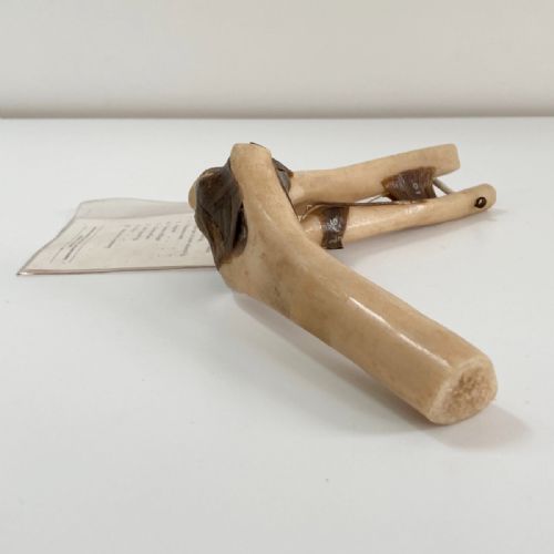 fig 3. A vintage plastic model of a right human elbow joint showing articulated ligaments alongside an original printed paper key card.
