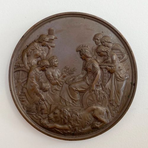 fig 2. An antique 1862 London International Exhibition bronze medal resting inside its original opened maroon presentation case with blue velvet lining.