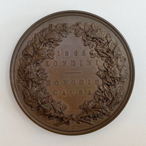 fig 3. An antique 1862 London International Exhibition bronze medal resting inside its original opened maroon presentation case with blue velvet lining.