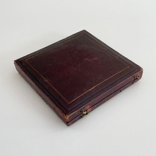 fig 4. An antique 1862 London International Exhibition bronze medal resting inside its original opened maroon presentation case with blue velvet lining.