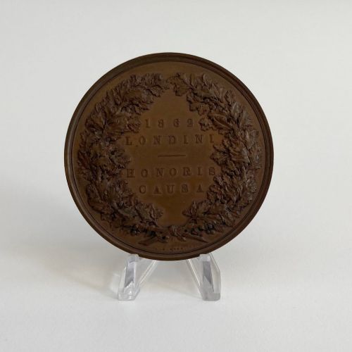 fig 6. An antique 1862 London International Exhibition bronze medal resting inside its original opened maroon presentation case with blue velvet lining.