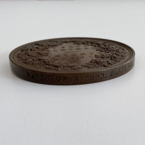 fig 8. An antique 1862 London International Exhibition bronze medal resting inside its original opened maroon presentation case with blue velvet lining.
