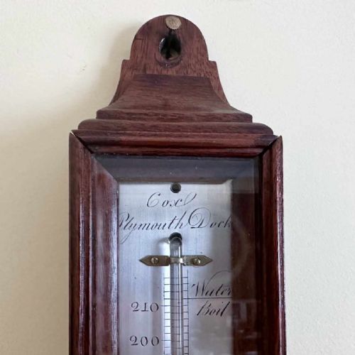 fig 3. A vertical George III mahogany cased wall thermometer featuring a glazed front, silvered register scale, and top hanging loop.