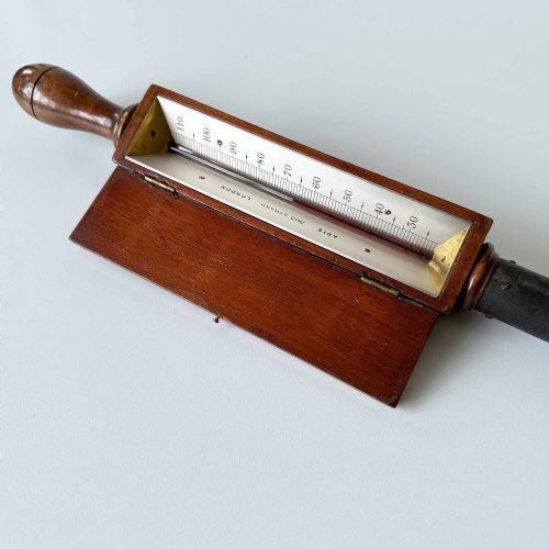fig 6. A Victorian hotbed soil thermometer featuring a long black pointed iron spike attached to a dark wooden housing with a open hinged protective lid revealing a glass scale.