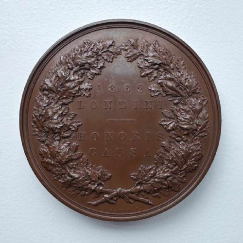 fig 1. A circular Victorian bronze exhibition medallion depicting classical allegorical figures, Britannia, and a reclining lion in high relief.