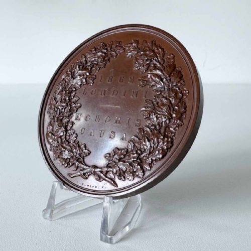 fig 2. A circular Victorian bronze exhibition medallion depicting classical allegorical figures, Britannia, and a reclining lion in high relief.