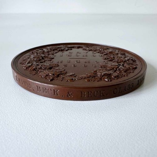 fig 4. A circular Victorian bronze exhibition medallion depicting classical allegorical figures, Britannia, and a reclining lion in high relief.