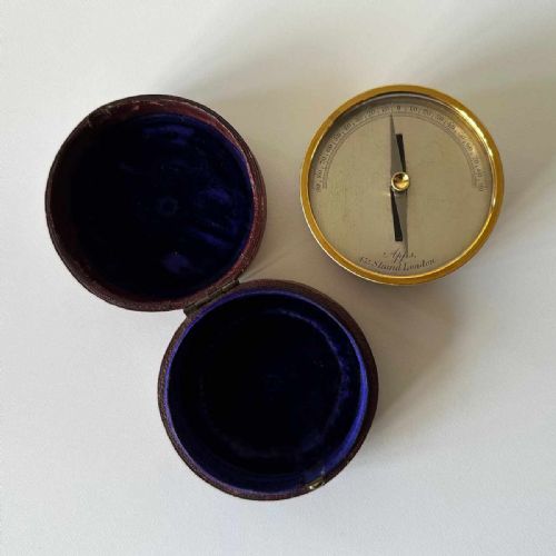 fig 1. A Victorian brass pocket galvanometer with a silvered dial housed inside a open dark leather protective case lined with blue velvet.
