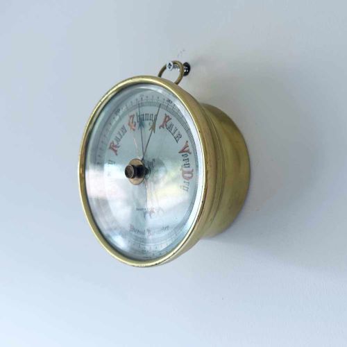 fig 3. A circular brass wall-hanging aneroid barometer featuring a silvered dial with Gothic lettering, calibrated scale, and multiple indicator pointers.