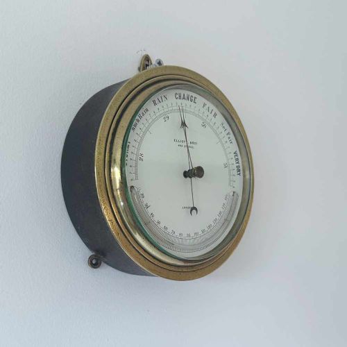 fig 1. A circular Victorian brass aneroid barometer featuring a white enamel dial with black atmospheric pressure readings and blued steel hands.