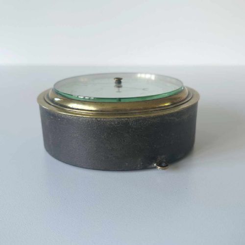 fig 3. A circular Victorian brass aneroid barometer featuring a white enamel dial with black atmospheric pressure readings and blued steel hands.