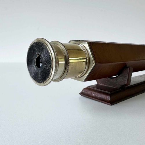 fig 6. A Victorian brass single draw marine telescope with a brown hexagonal barrel mounted on a dark wooden display stand.