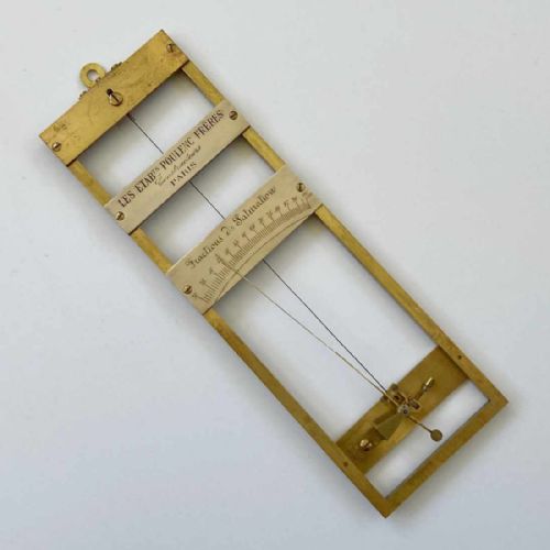 fig 1. A rectangular brass-framed Saussure hair hygrometer featuring engraved text plates and a curved graduated scale with a pointer needle.