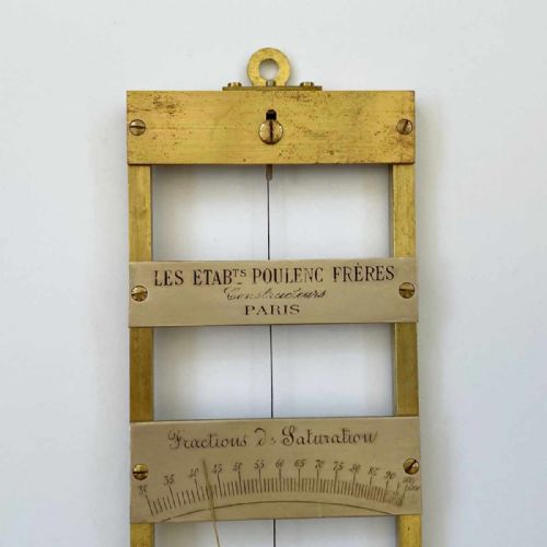 fig 3. A rectangular brass-framed Saussure hair hygrometer featuring engraved text plates and a curved graduated scale with a pointer needle.