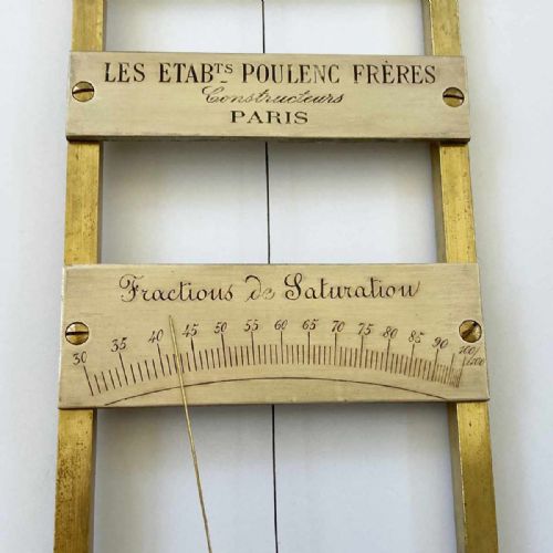 fig 4. A rectangular brass-framed Saussure hair hygrometer featuring engraved text plates and a curved graduated scale with a pointer needle.