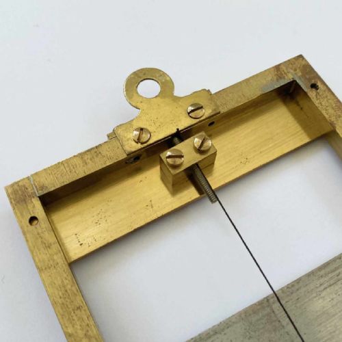 fig 7. A rectangular brass-framed Saussure hair hygrometer featuring engraved text plates and a curved graduated scale with a pointer needle.
