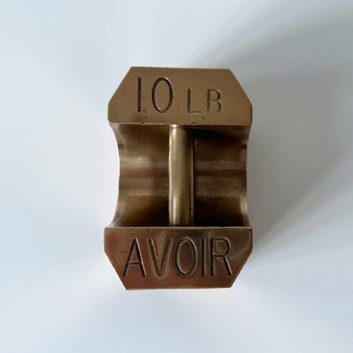 fig 9. A set of four graduated Edwardian brass avoirdupois standard weights displaying engraved weight values ranging from five to fifty pounds.