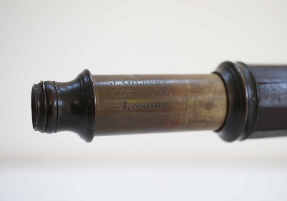 A mid-eighteenth-century dark mahogany decagonal optical telescope mounted horizontally on a matching dark wooden display stand. View III