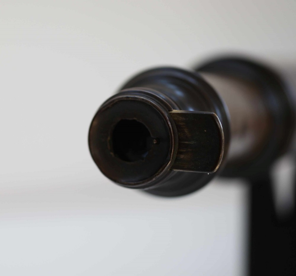 A mid-eighteenth-century dark mahogany decagonal optical telescope mounted horizontally on a matching dark wooden display stand. View V