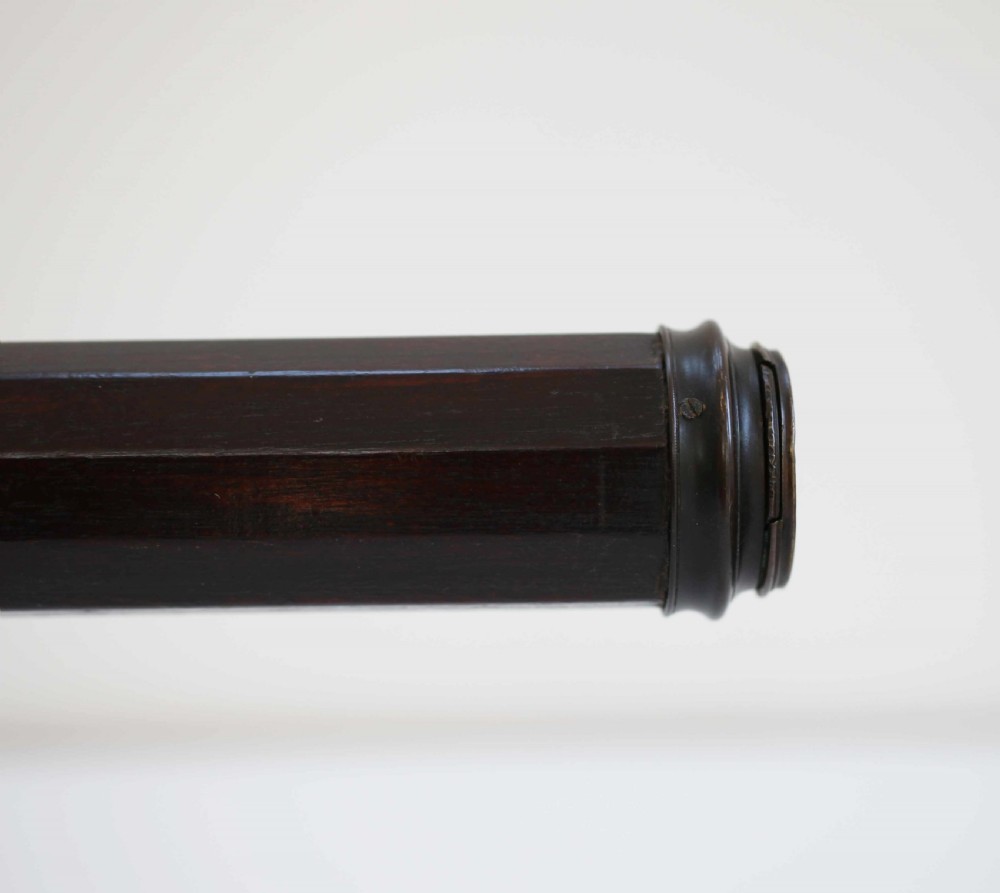 A mid-eighteenth-century dark mahogany decagonal optical telescope mounted horizontally on a matching dark wooden display stand. View VII