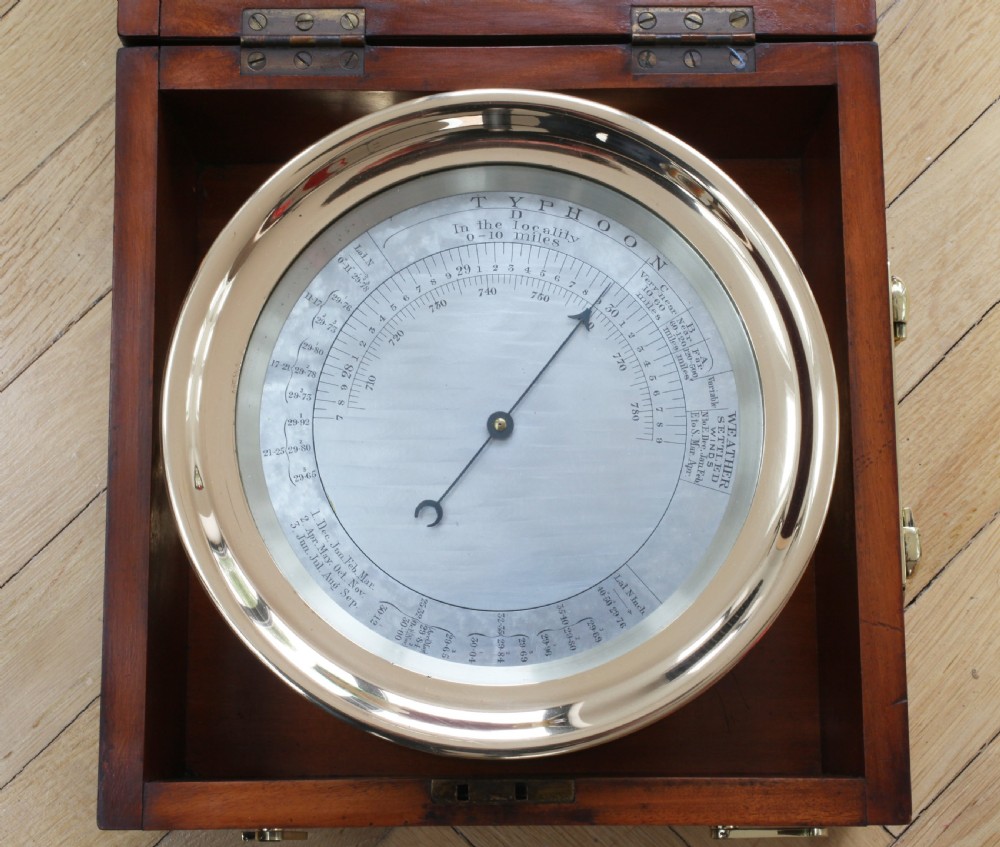 An early twentieth-century barocyclonometer housed in a hinged mahogany box, featuring a circular brass typhoon barometer in the lower section and a directional cyclone dial mounted in the upper lid. View VI