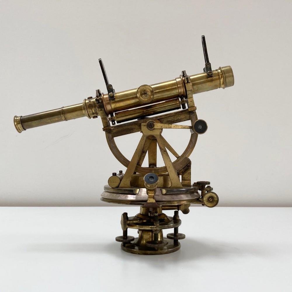 A William IV miniature brass altazimuth theodolite featuring a central sighting telescope, vertical semicircular scale, horizontal vernier plate, and levelling screws.