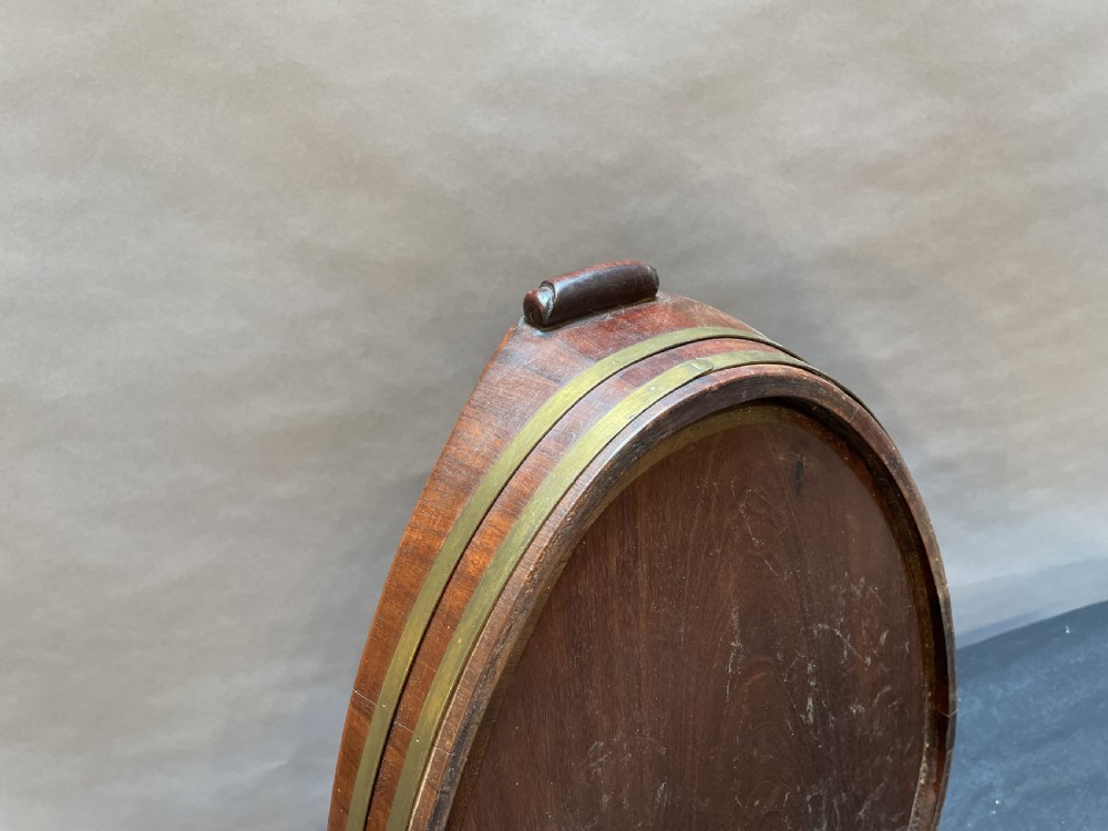 A Georgian Revival oval mahogany serving tray featuring a raised rim, integrated handles, and a brass band outer trim. View VIII