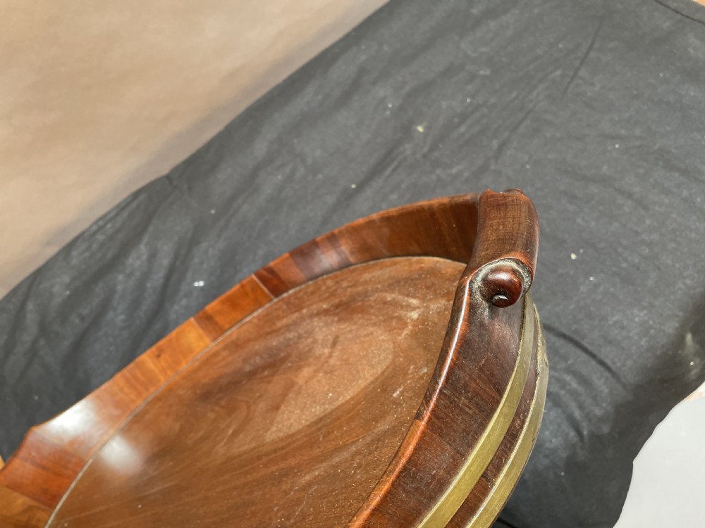 A Georgian Revival oval mahogany serving tray featuring a raised rim, integrated handles, and a brass band outer trim. View IX