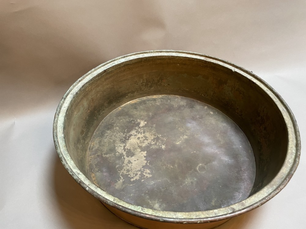 A large nineteenth-century circular copper preserve pan featuring flared sides, a rolled rim, and an aged interior showing signs of historical wear. View V