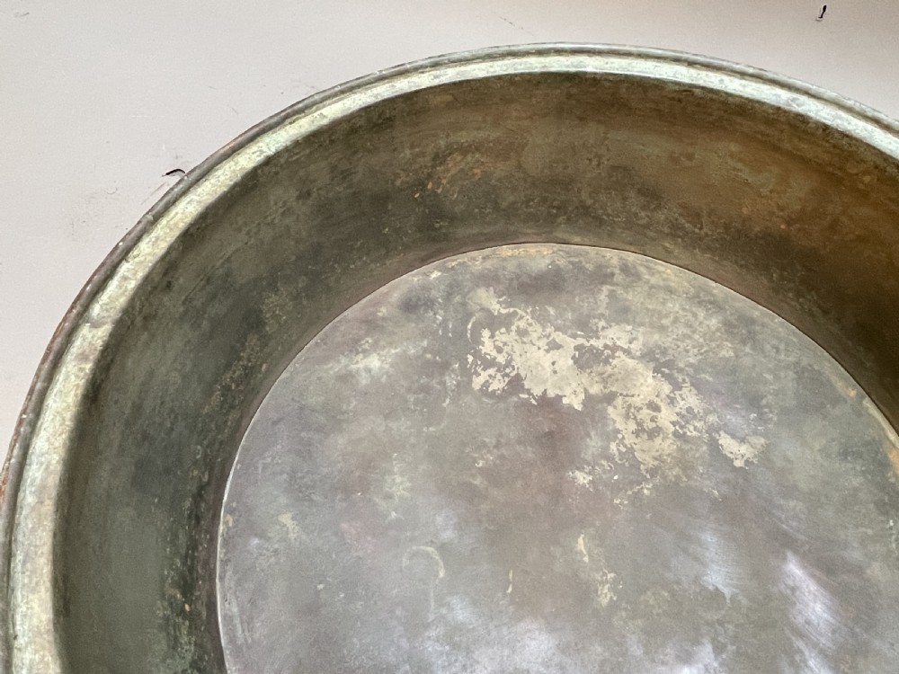 A large nineteenth-century circular copper preserve pan featuring flared sides, a rolled rim, and an aged interior showing signs of historical wear. View X