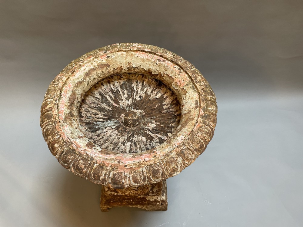 A Victorian cast iron garden urn with a fluted rim and laurel wreath medallion base, displaying a weathered white paint finish over oxidised iron. View II