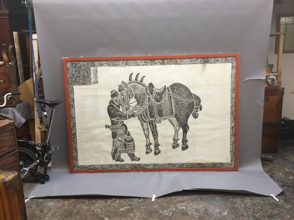 A large monochrome framed paper rubbing depicting a groom attending to a saddled Tang Dynasty horse. View VII